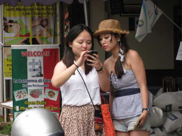 Two Chinese tourists using a mobile phone